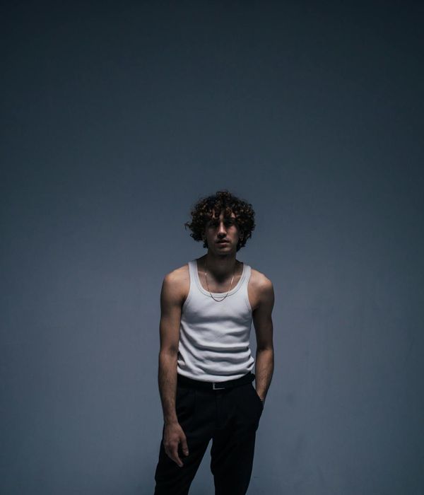 Man performing a controlled strength exercise in a minimalist dark room.